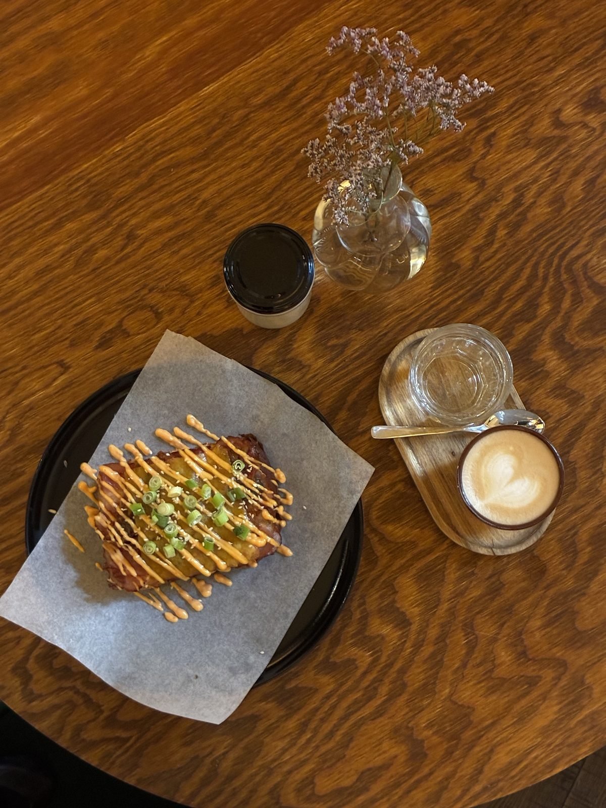 Tom's toust – brioška se slaninou, čedarem a sriracha mayo, vedle cappuccino